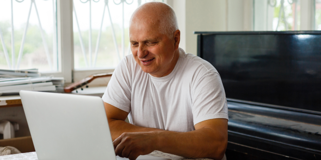 Man smiling at laptop - volunteering story